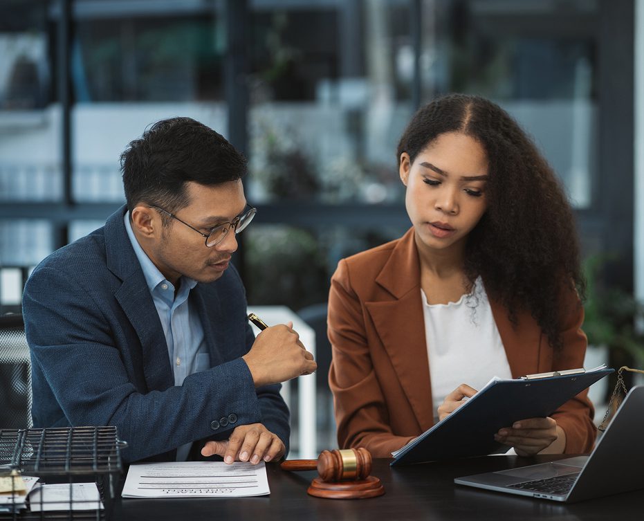 Colleagues discussing paperwork in an office.