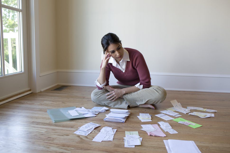 Woman organizing bills on the floor