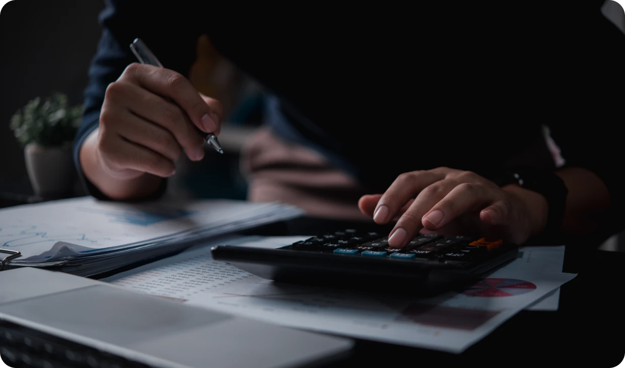 Close-up of hands with calculator and papers