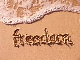 Beach sand with "freedom" and sea foam