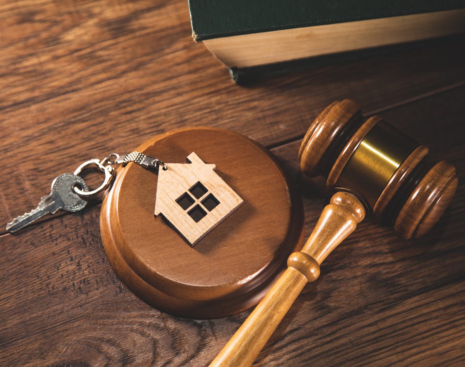 Gavel and house key on wooden desk