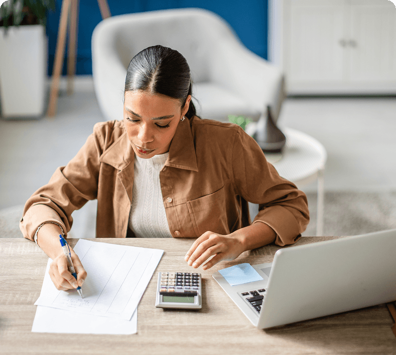 Woman working with papers and a laptop.